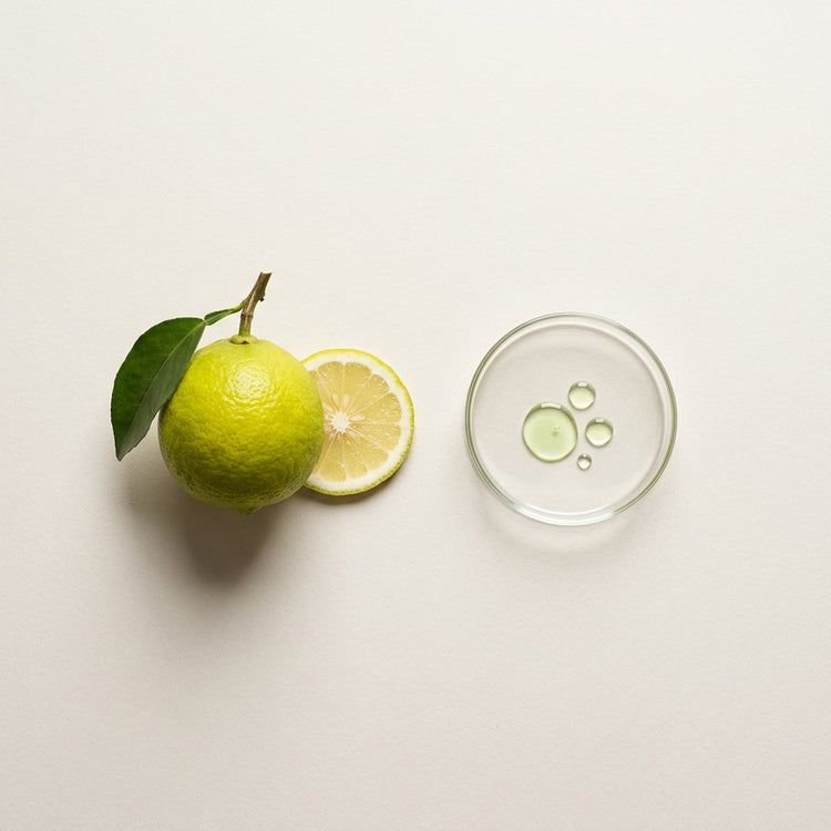 Bergamot (FCF): a bergamot fruit, a leaf and a slice, beside a small glass dish of the oil.
