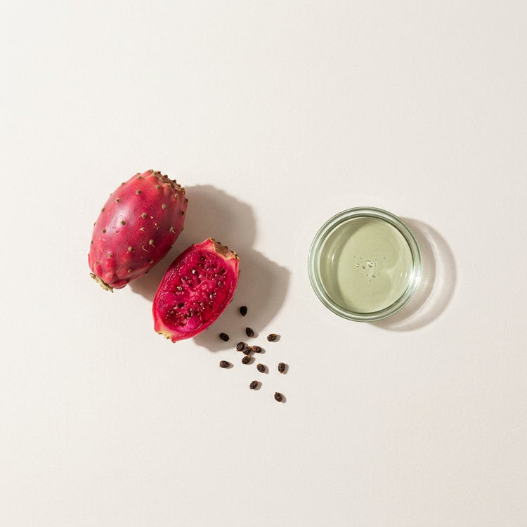 Prickly Pear Seed: prickly pear fruits, one cut open, beside a small glass dish of the oil.